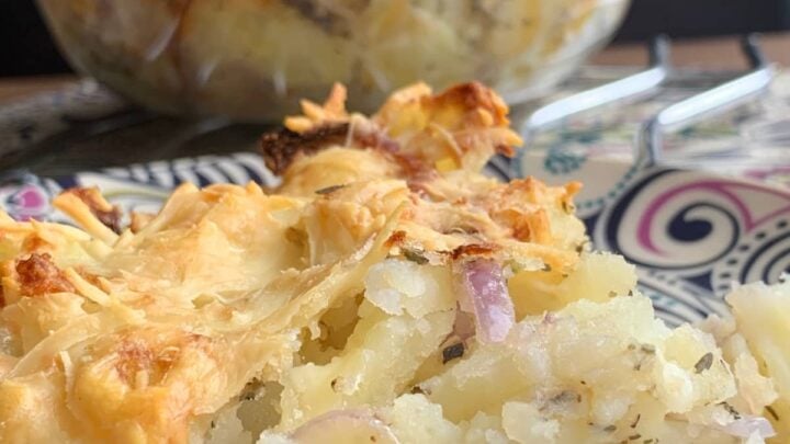Cheesy Oven-Baked Garlic Potatoes. A simple, easy side dish recipe, with fluffy potatoes, cheese, and onions, baked in a tasty garlic and herb mix. The perfect cheesy potato bake!